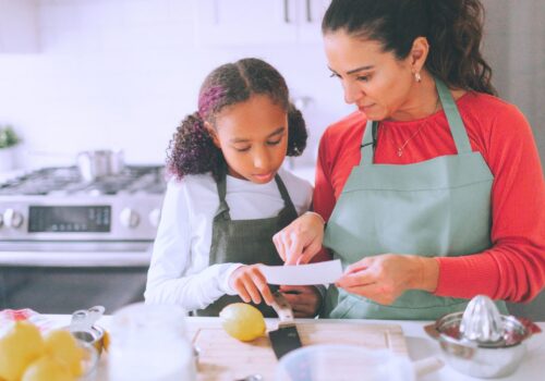 maman en train d'initier son enfant à la cuisine en faisant une recette
